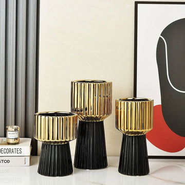 Modern ceramic vase in gold, white, and black colors.